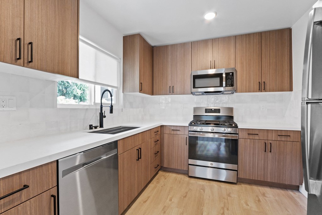 a modern kitchen with wooden cabinets and stainless steel appliances