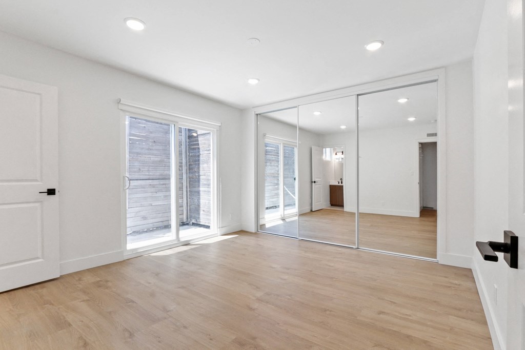 a living room with white walls and sliding glass doors