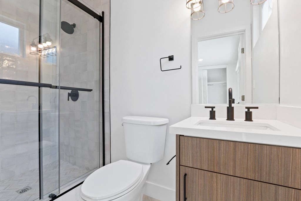 a white bathroom with a toilet and a shower