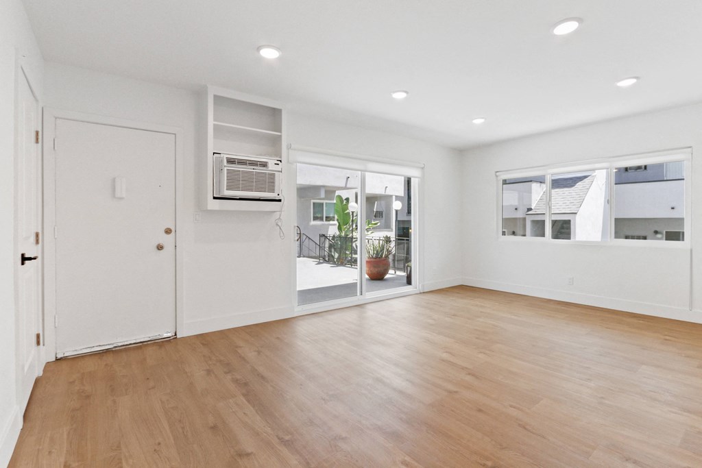 an empty living room with white walls and wood flooring
