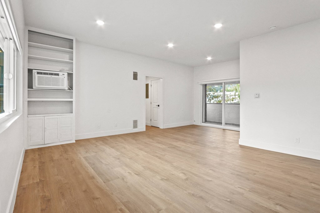 an empty living room with white walls and wood flooring