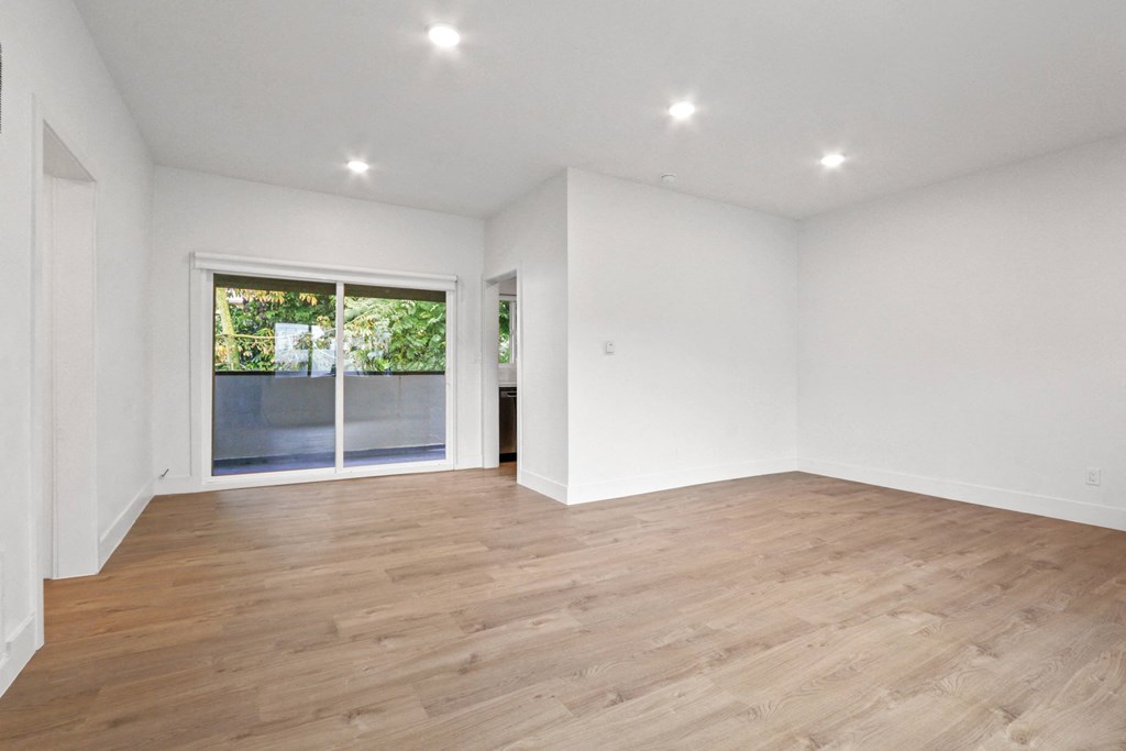 a living room with white walls and a sliding glass door