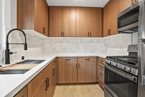 a kitchen with wooden cabinets and a sink and a stove