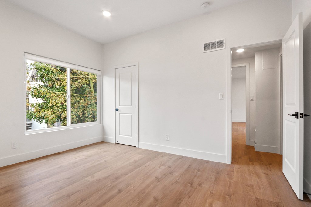 an empty living room with white walls and a window