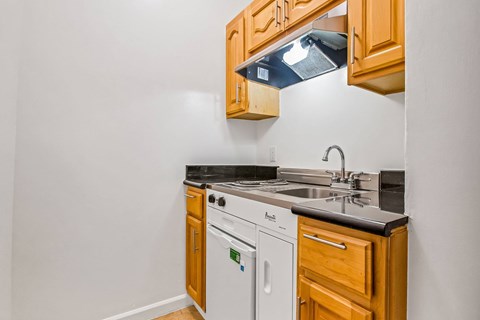 A kitchen with wooden cabinets and a white dishwasher.