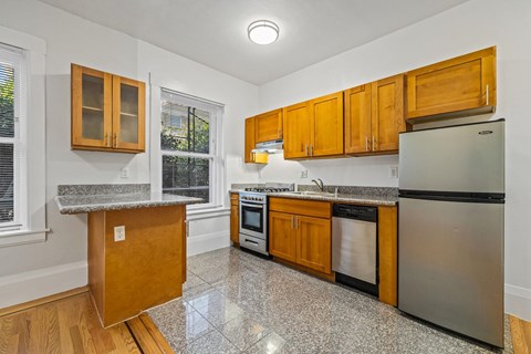 A kitchen with wooden cabinets and a granite countertop.