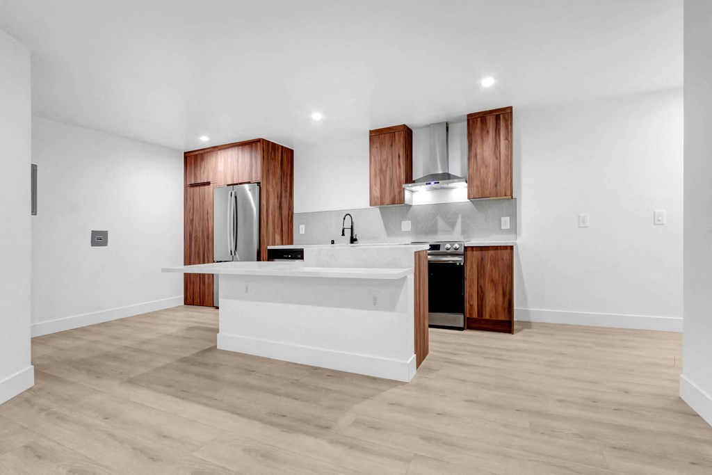 a white kitchen with wooden cabinets and a white counter top