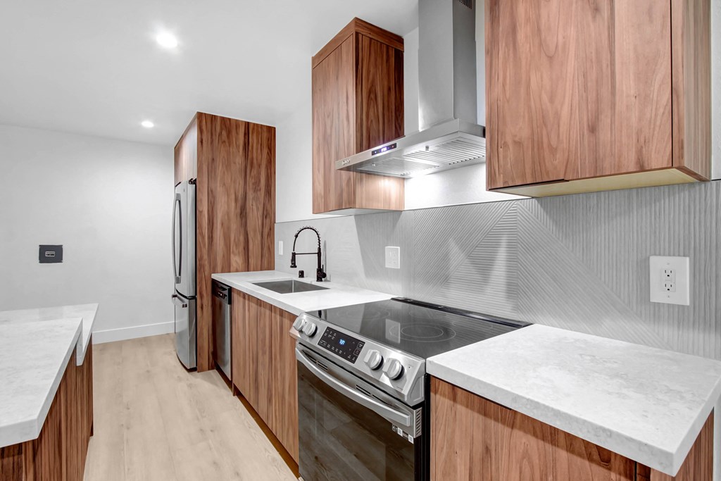 a kitchen with wooden cabinets and white counter tops and a stainless steel stove