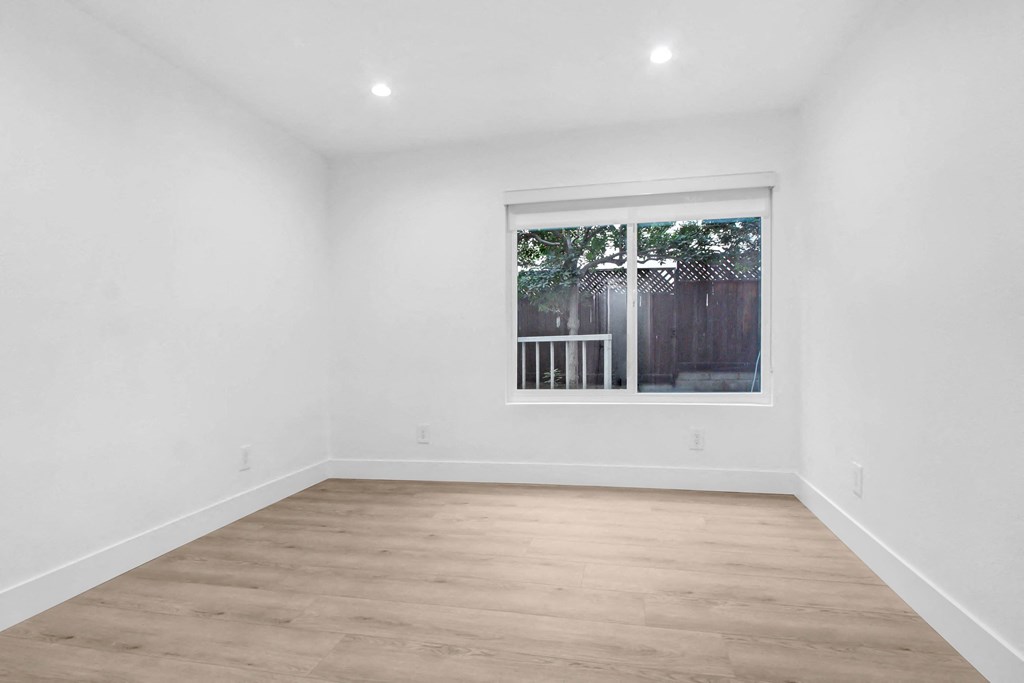 a living room with white walls and a window