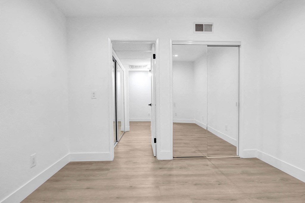 a renovated living room with white walls and wood floors