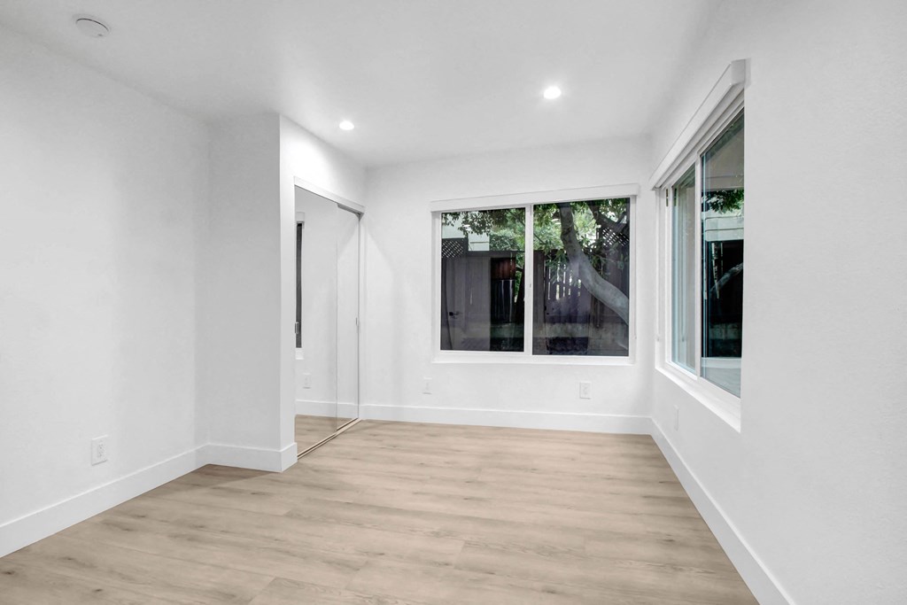 a living room with white walls and a large window