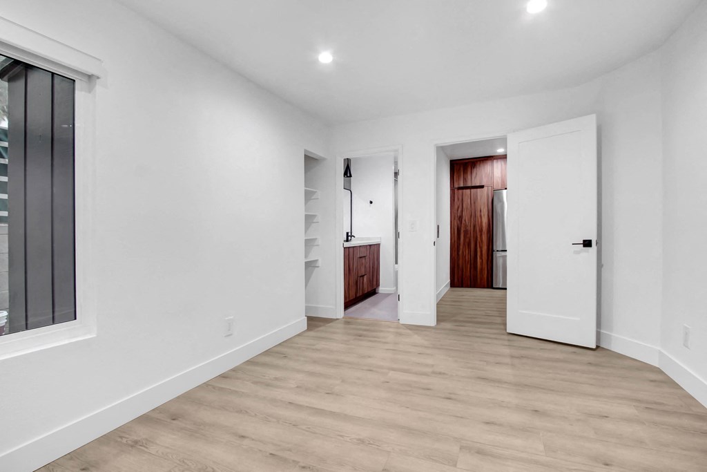 a renovated living room with white walls and wood floors