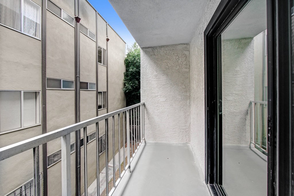 a balcony with a white railing and a glass door