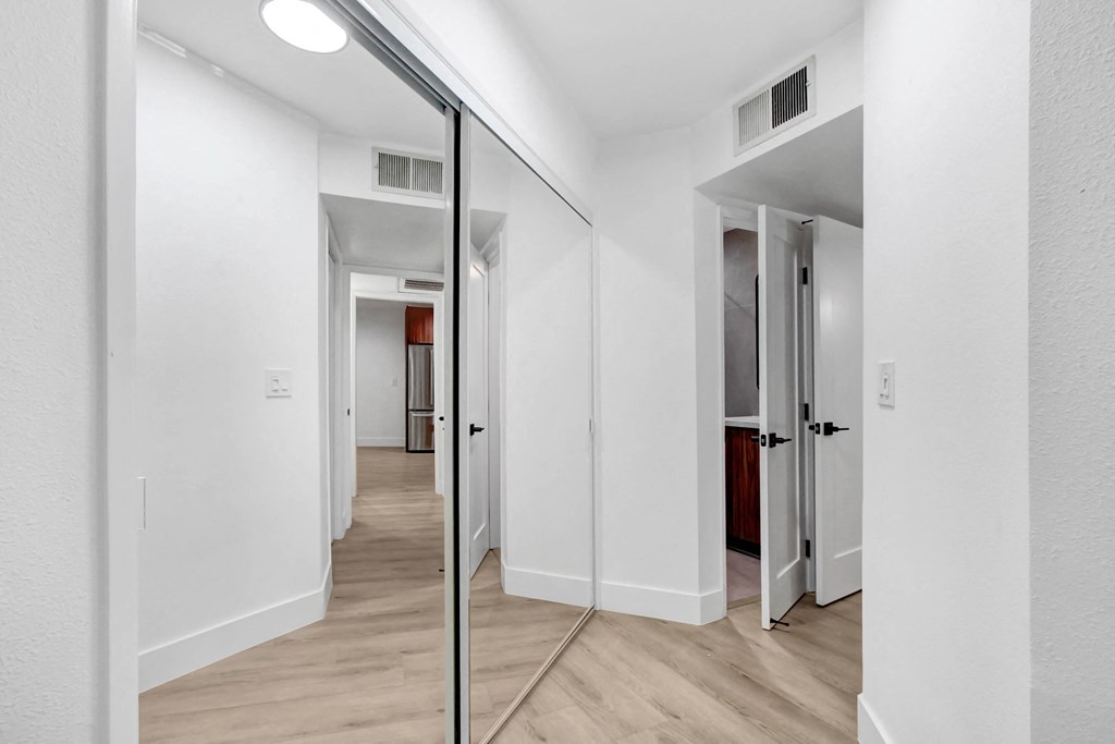 a sliding glass door leading to a bedroom and a hallway with white walls and ceilings