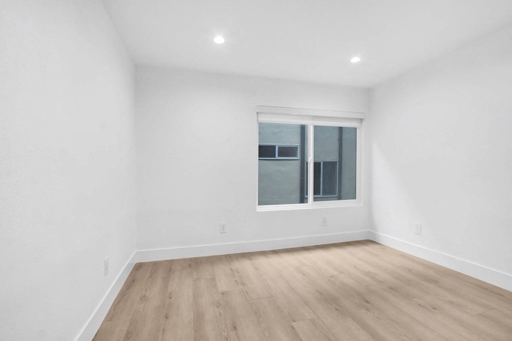 a living room with white walls and a window