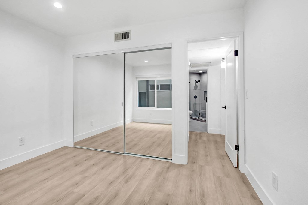 a living room with white walls and sliding glass doors to a bathroom
