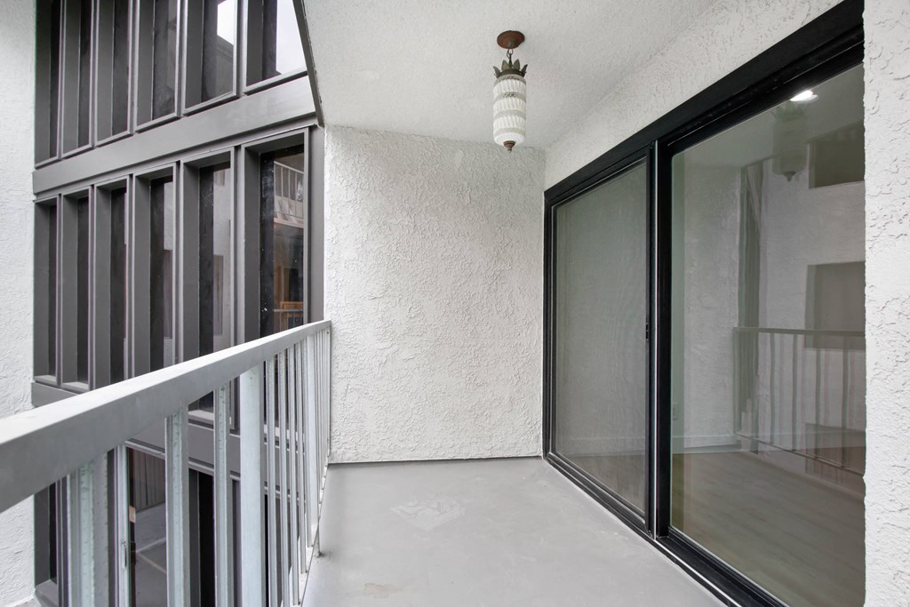 a balcony with a glass door and a white ceiling light