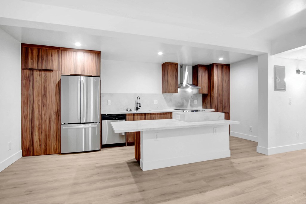 a kitchen with a white counter top and a stainless steel refrigerator