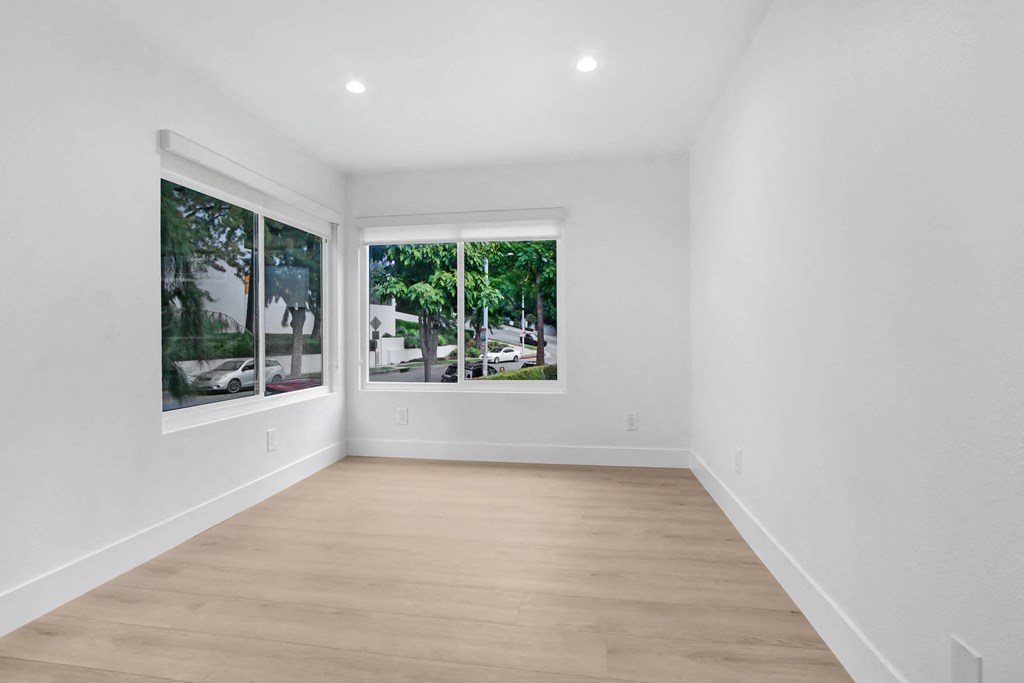 a living room with white walls and large windows