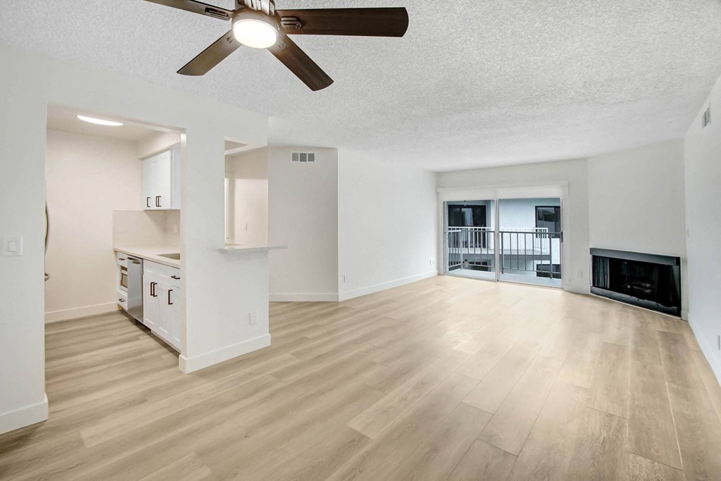 an open living room and kitchen with a ceiling fan