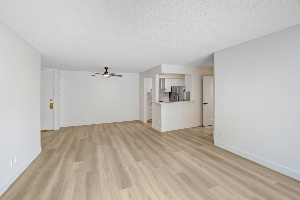 the spacious living room and dining room of an apartment