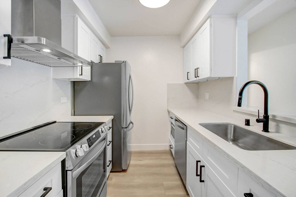 a kitchen with white cabinets and a stainless steel refrigerator