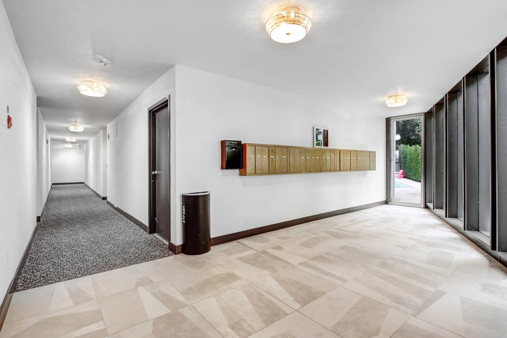 a long hallway with white walls and wood cabinets on the wall