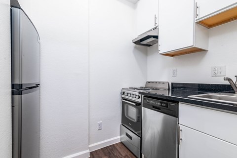 A kitchen with a stainless steel refrigerator and a stainless steel dishwasher.
