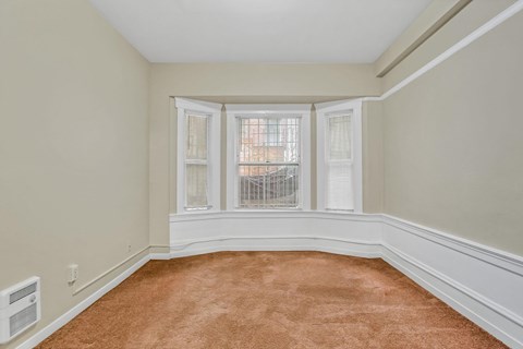 A room with a window and a carpet.