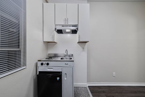 A small kitchen with a black dishwasher and a white fridge.