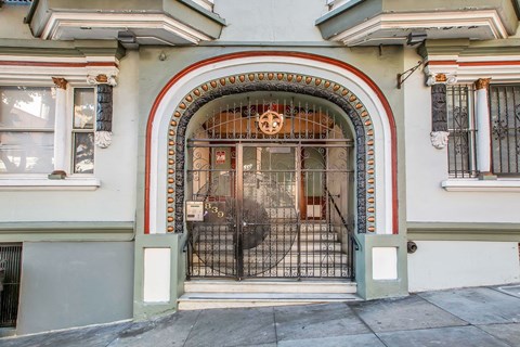 A building with a large arched doorway and a metal gate.