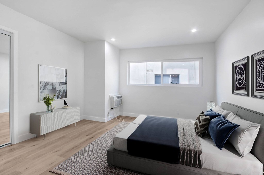 A bedroom with a large bed and a window.