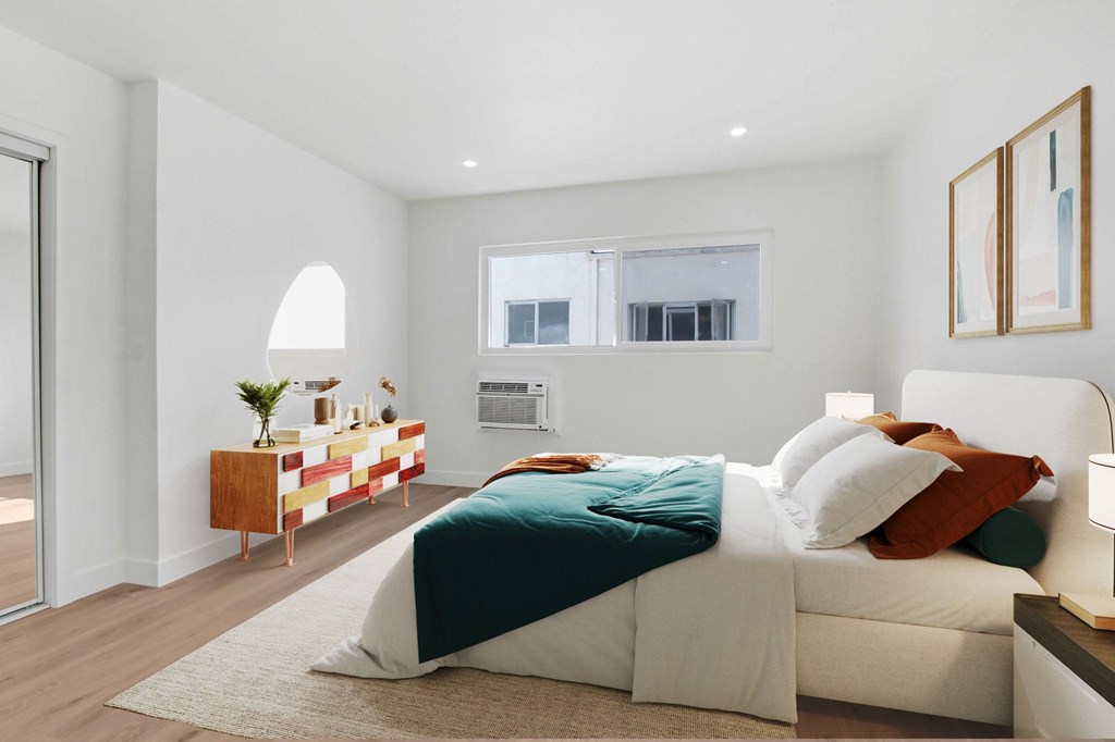 A bedroom with a bed, nightstand, and lamp.