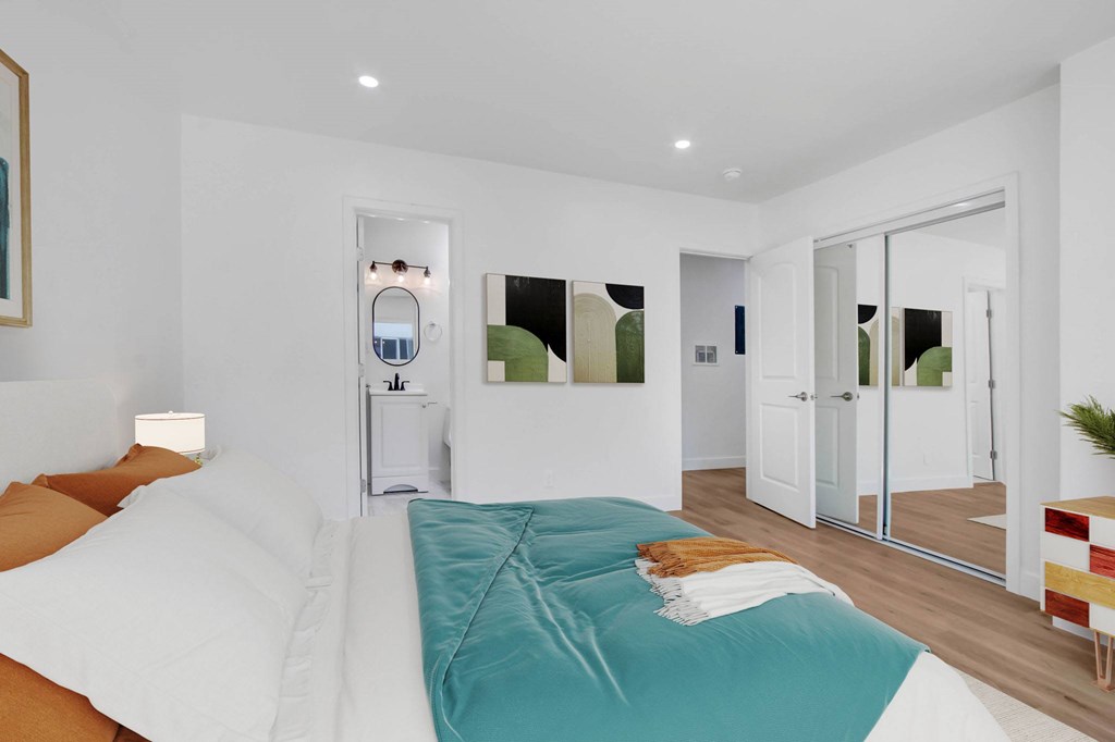 A bedroom with a bed and a mirror on the wall.