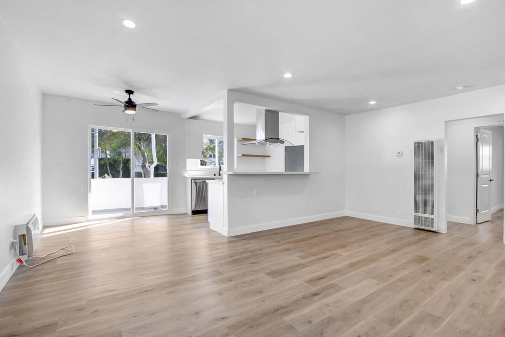 a living room with white walls and a sliding glass door