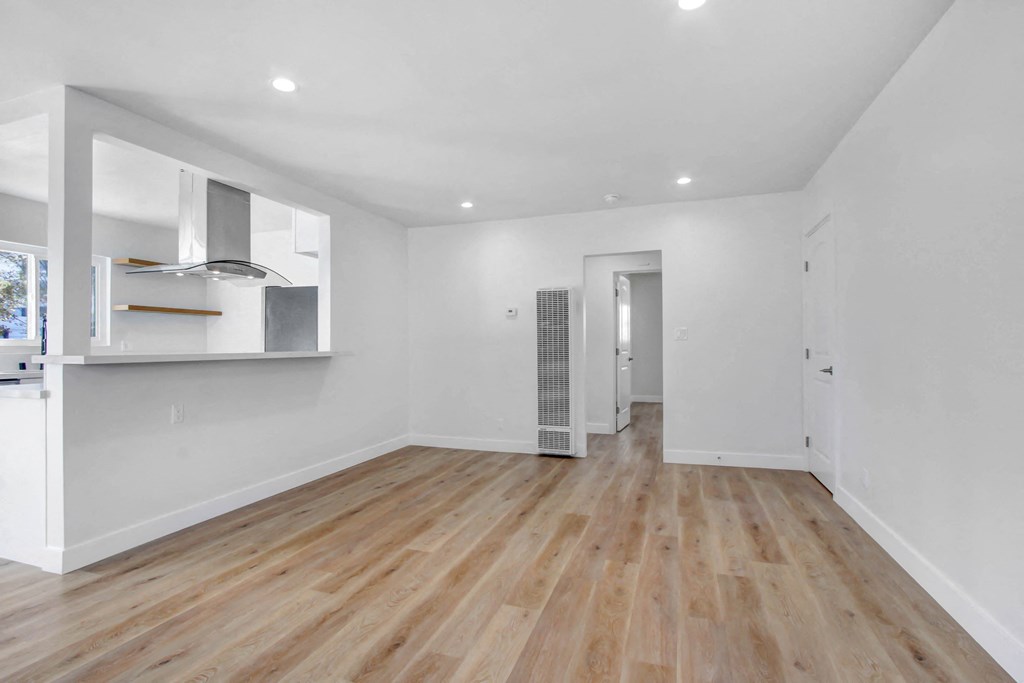 a living room with white walls and a hard wood floor