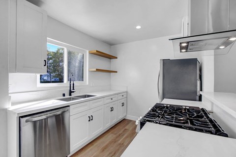 A modern kitchen with white cabinets and a stainless steel dishwasher.