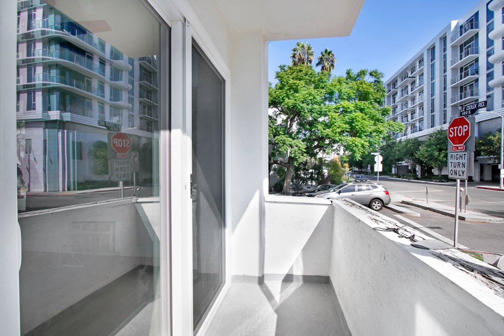 a balcony with a view of a city street and a stop sign