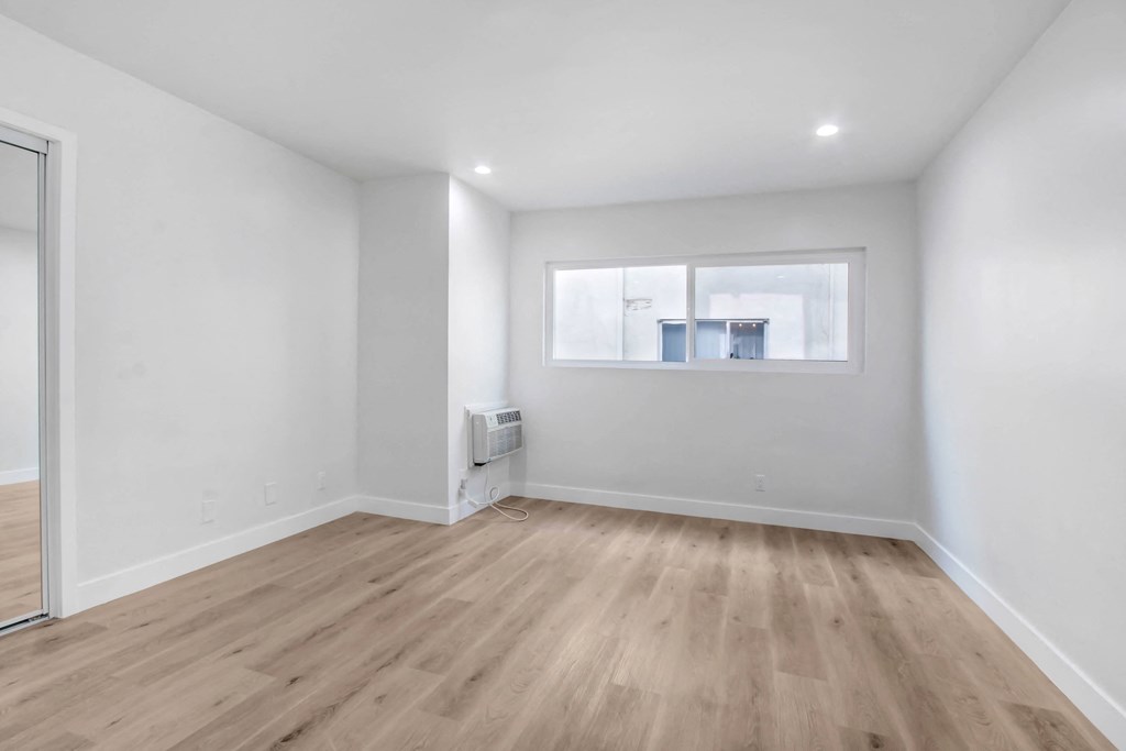 a living room with white walls and a window