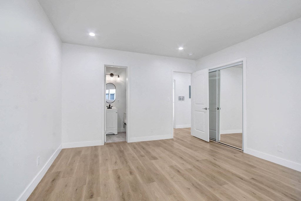 a renovated living room with white walls and wood flooring