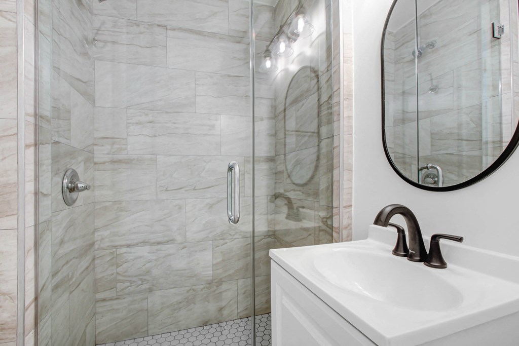 a bathroom with a shower and a sink and a mirror