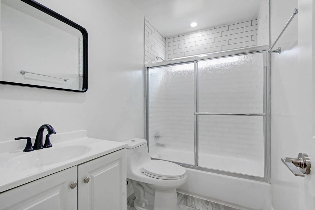 a white bathroom with a shower sink and toilet