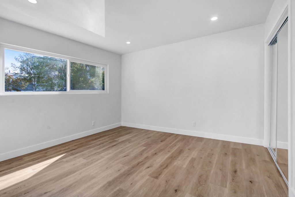 an empty room with white walls and a window