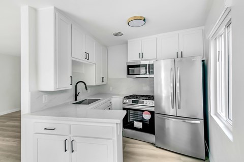 A kitchen with white cabinets and stainless steel appliances.