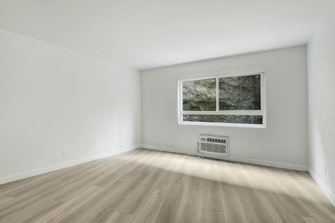 A room with a window and a wall-mounted air conditioner.