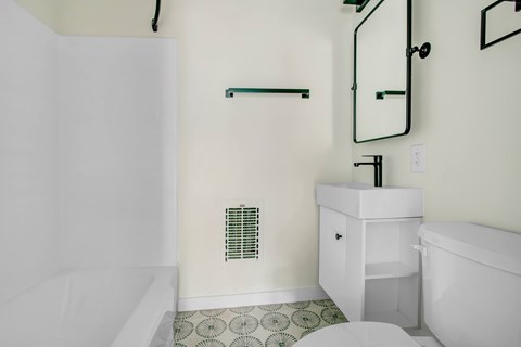 A white bathroom with a toilet, sink, and shower.