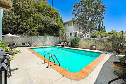 A small pool with a concrete floor and a wall surrounding it.