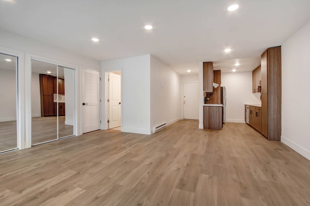 A room with wooden flooring and white walls.