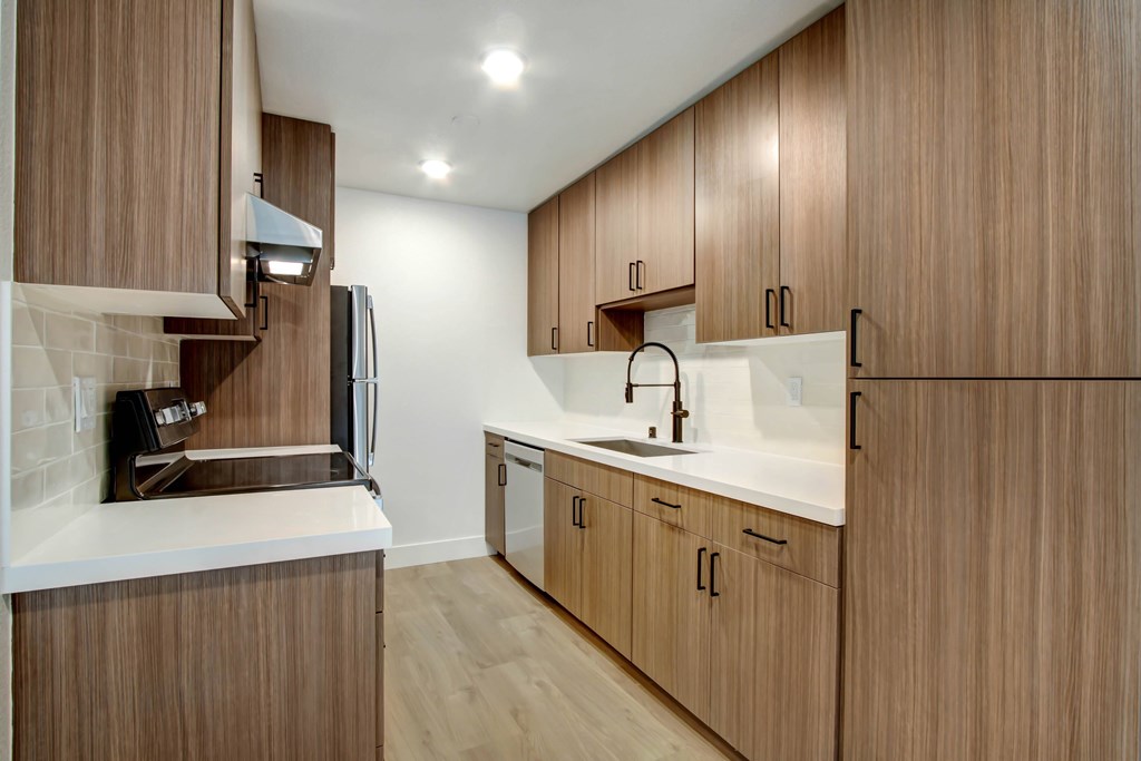 A kitchen with wooden cabinets and a white counter.