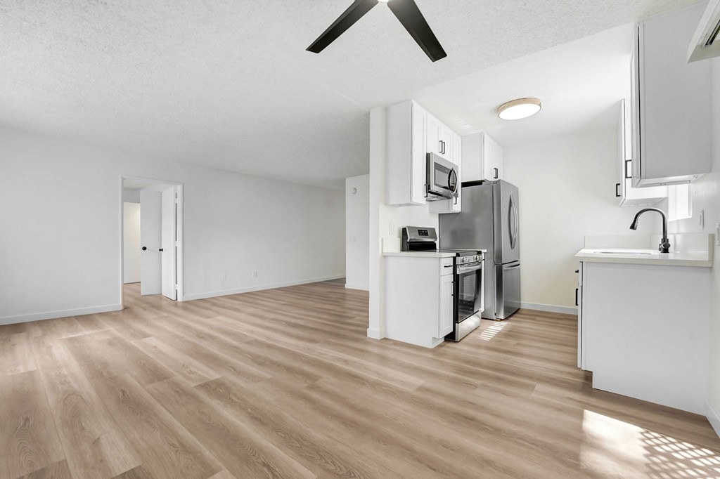 A kitchen with a refrigerator, microwave, and oven.